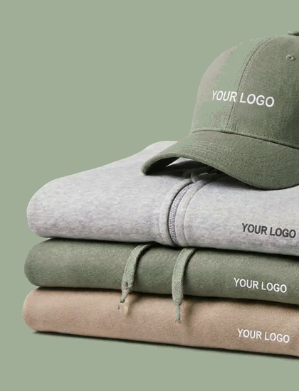 Image Sweats � capuche empil�s gris, vert et beige, surmont�s d'une casquette verte, chacun avec un emplacement pour logo