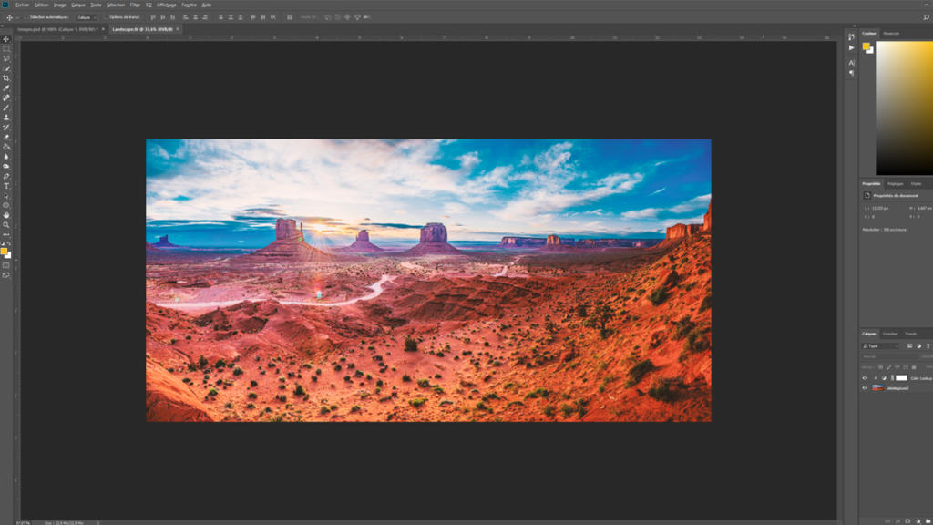 Une image numérique de Monument Valley, idéale pour ceux qui cherchent à créer des données d'impression, est affichée dans un logiciel de retouche photo. Le paysage met en valeur les superbes formations rocheuses rouges sur un ciel bleu nuageux, le tout entouré des nombreux outils et options du logiciel.