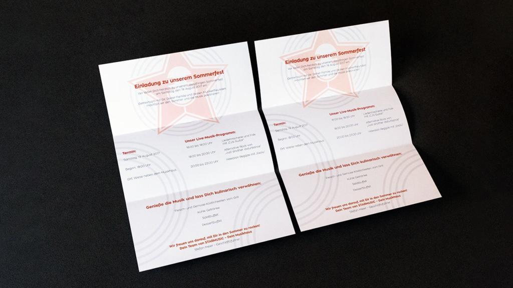 Deux dépliants ouverts sur une surface sombre présentent un texte en allemand, avec une étoile centrale sur chaque page. Le texte semble être une invitation à un festival d'été, avec les détails et les horaires de l'événement.
