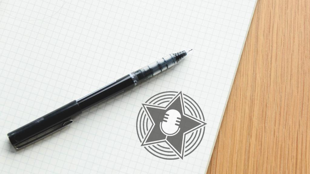Un stylo noir est posé sur une feuille de papier millimétré, à côté d'un dessin imprimé représentant un microphone dans une étoile, entouré de lignes circulaires. Le papier repose partiellement sur une surface en bois.