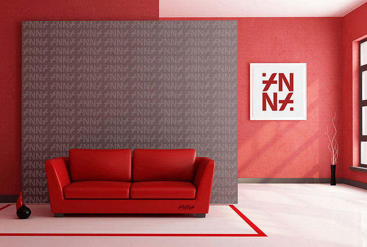 Un salon moderne aux murs rouges arbore un texte ambigramme saisissant derrière un canapé rouge. Une œuvre d'art abstraite encadrée orne un mur adjacent. La lumière du soleil filtre à travers de grandes fenêtres, illuminant l'espace, tandis qu'un vase minimaliste ajoute une touche décorative à droite.