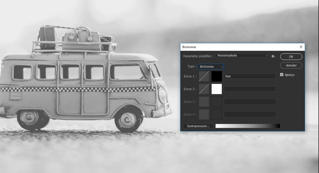 Une image en noir et blanc représente une camionnette avec des bagages sur le toit. Au premier plan, une fenêtre d'édition monochrome de Photoshop est ouverte, affichant les options de réglage de la bichromie. L'arrière-plan est flou.
