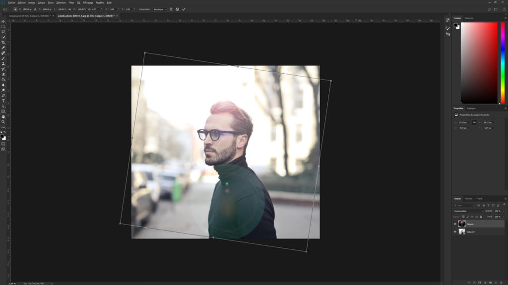 Une personne portant un col roulé foncé et des lunettes se tourne pour regarder par-dessus son épaule dans une rue. L'image, rehaussée par un effet de flare dans Photoshop, est ouverte dans le logiciel, avec les outils et réglages visibles sur les côtés.