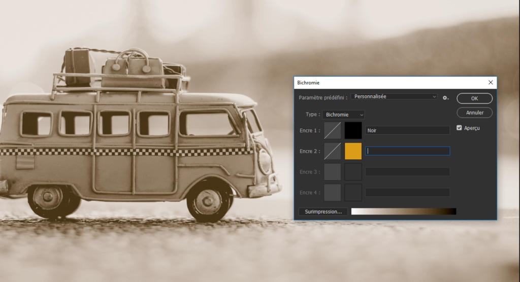 Une image aux tons sépia d'un bus jouet vintage avec des bagages sur le dessus s'intègre parfaitement aux paramètres Bichromie de Photoshop, où les options de couleur sont affichées sur le côté droit de l'interface de l'outil d'édition numérique.