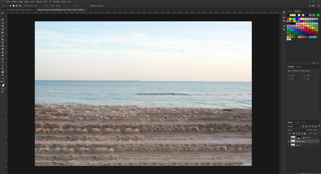 Une interface de retouche photo numérique présente une plage sereine avec de douces vagues, un rivage sablonneux et un ciel paisible. Grâce à des outils comme « flouter une photo avec Photoshop », l'espace de travail propose diverses options de retouche et palettes de couleurs sur les côtés.