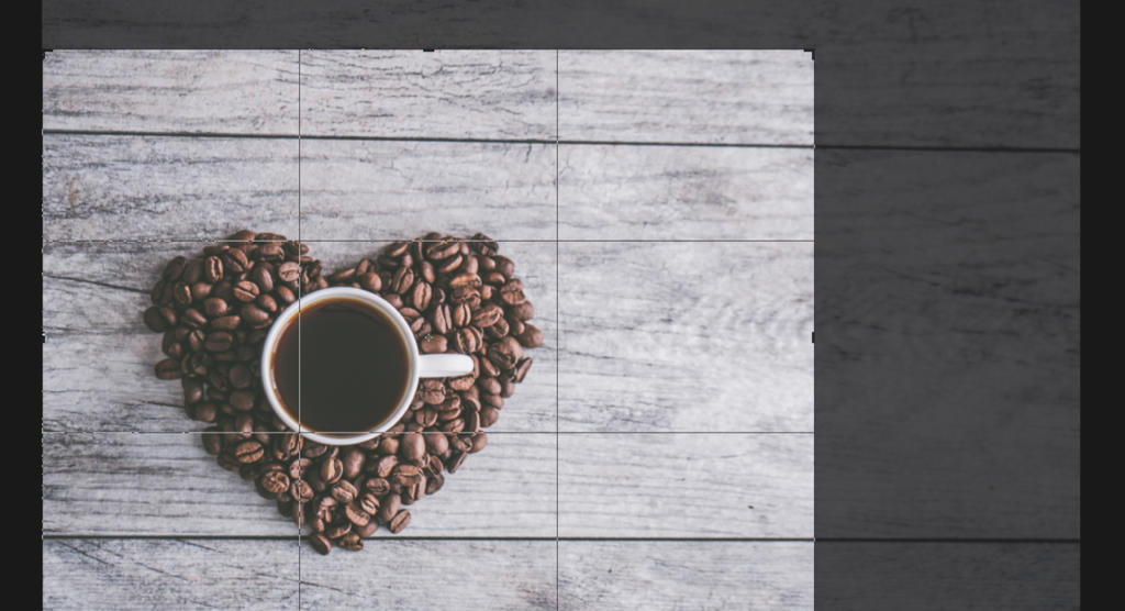 Une tasse de café noir est posée sur une surface en bois, encadrée par un cœur en grains de café. La texture légère et patinée du bois lui confère une touche rustique, comme si la scène avait été détourée d'une image pour en capturer l'essence chaleureuse.
