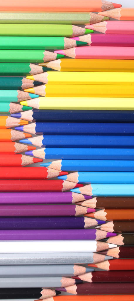 Une collection de crayons de couleur soigneusement disposés, alignés en alternance sur deux rangées verticales. Les crayons présentent un spectre de couleurs vives, incluant le vert, le jaune, le bleu, le rouge, le violet, le marron et le gris, avec leurs pointes pointues se faisant face.