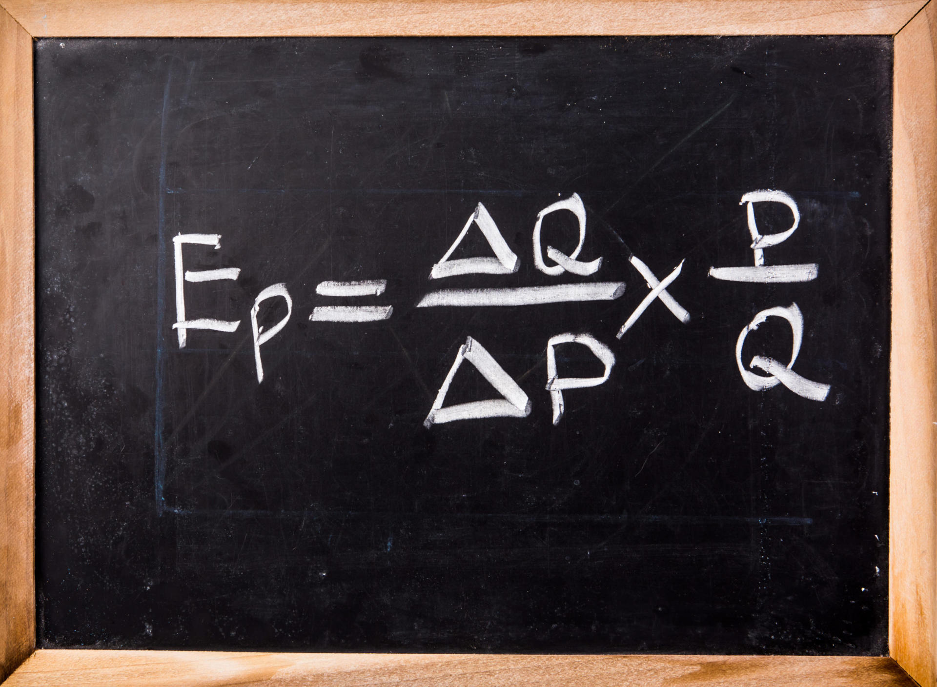 Un tableau noir présente l'équation de l'élasticité-prix de la demande : Ep = (ΔQ / ΔP) × (P / Q), soigneusement écrite à la craie blanche. Cette formule essentielle de l'« élasticité-prix » est présentée sur un fond noir saisissant, encadré par une bordure en bois classique.